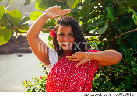 portrait of attractive indian female model in vacation on paradise tropical beach by ocean sea. hindu woman with kundan jewelry set traditional India costume red wedding sari.asian girl sensual look 90039610