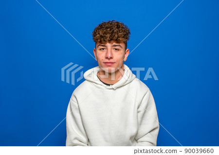 Portrait of the young happy smiling man isolated on a blue background Portrait of the young happy smiling man isolated on a blue background 90039660