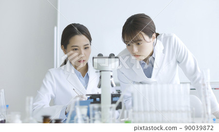 Female experiment in a white coat doing research 90039872