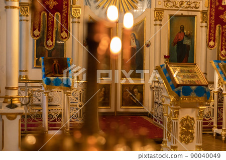 Orthodox Church. Christianity. Festive interior decoration with burning candles and icon in traditional Orthodox Church on Easter Eve or Christmas. Religion faith pray symbol 90040049