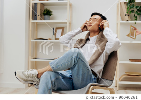 man sweater on the shoulders headphones music sitting in the room Lifestyle 90040261