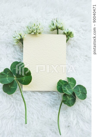 Mockup of a blank card decorated with white clover's five-leaf, four-leaf and flowers on a white fluffy blanket background Mockup of a blank card decorated with white clover's five-leaf, four-leaf and flowers on a white fluffy blanket background 90040471