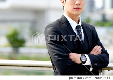 A smiling businessman man with his arms folded 90040611