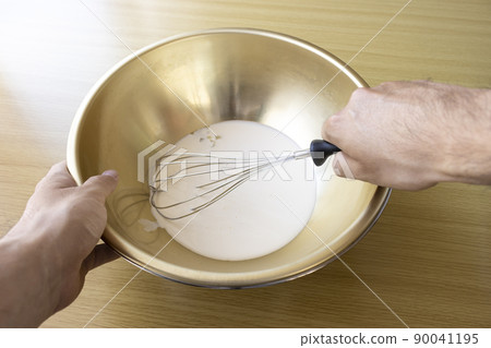 Image of a man whisk cream with a whisk 90041195