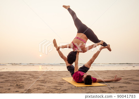 muladhara swadhisthana manipula tantra yoga on the beach man and woman meditates sitting on the sand by the sea at sunset romantic Valentine's Day.couple practicing yoga steam muladhara swadhisthana manipula tantra yoga on the beach man and woman meditates sitting on the sand by the sea at sunset romantic Valentine's Day.couple practicing yoga steam 90041783