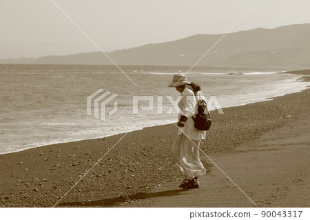 A woman walking along the beach in Odawara 90043317