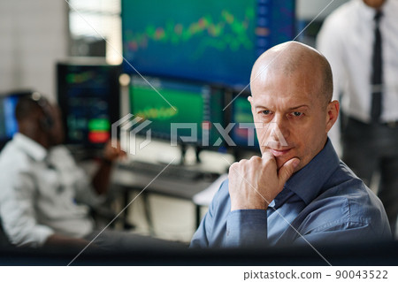 Mature Caucasian man working in stock trading market watching charts and graphs of currency on monitor in office 90043522