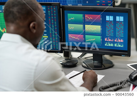 African American man working on stock trading watching charts and graphs of currency, selective focus shot African American man working on stock trading watching charts and graphs of currency, selective focus shot 90043560