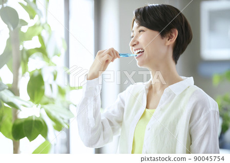 Middle woman brushing teeth Middle woman brushing teeth 90045754