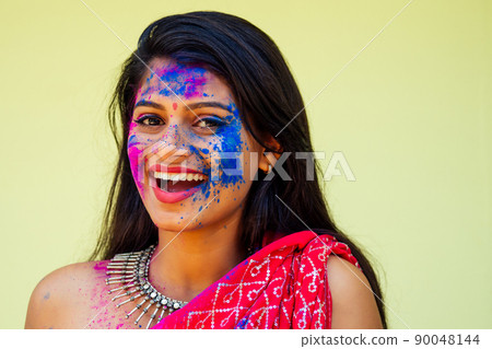 Holi Festival Of Colours. Portrait of happy indian girl in traditional hindu sari on holi color . india woman silver jewelry with powder paint on dress ,colorful pink and blue hair in Goa Kerala 90048144