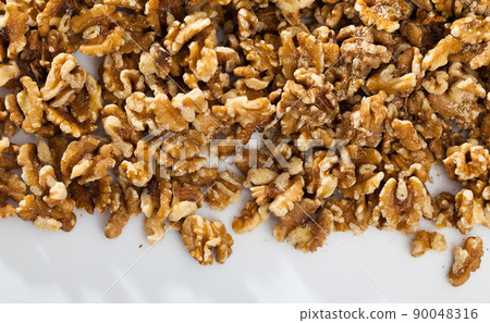 Dry peeled walnut in glass bowl on white background, nobody 90048316