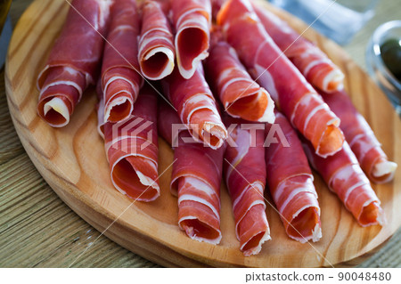 Traditional Spanish meal - rolls of iberian jamon served at plate 90048480