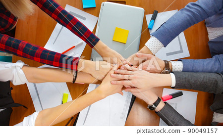 Business concept. A working team put their hands together Business concept. A working team put their hands together 90049157