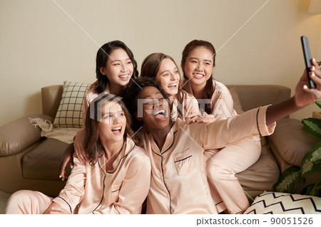 Friends in Pajams Taking Selfie 90051526