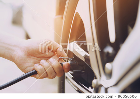 close up hand man car parking a check and inflate the tire fill up the air for safe driving on the go. Transportation travel vehicle concept. 90056500