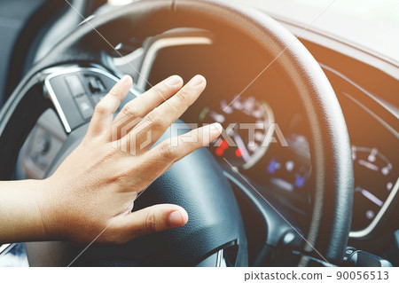 person pushing horn while driving sitting of a steering wheel press car, honking sound to warn other people in traffic concept. person pushing horn while driving sitting of a steering wheel press car, honking sound to warn other people in traffic concept. 90056513