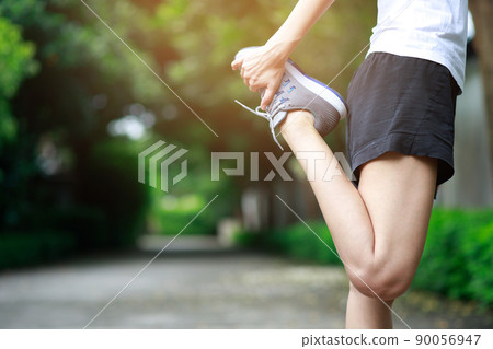 young female runner stretching for warming up before running or working out on the park. Track and Field Athlete exercise. Fitness and sport healthy lifestyle concept. young female runner stretching for warming up before running or working out on the park. Track and Field Athlete exercise. Fitness and sport healthy lifestyle concept. 90056947