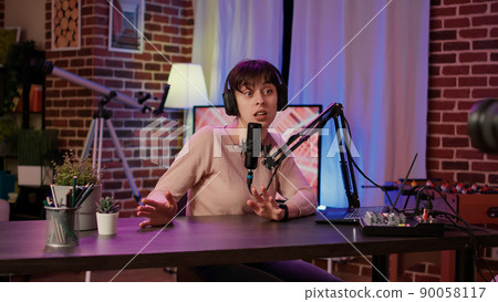 Selective focus on digital video camera screen recording caucasian vlogger talking to audience from home podcasting studio. Woman influencer filming herself doing live broadcast for social media. Selective focus on digital video camera screen recording caucasian vlogger talking to audience from home podcasting studio. Woman influencer filming herself doing live broadcast for social media. 90058117