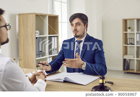 Meeting in office of law firm of male lawyer and his business client for legal advice. Meeting in office of law firm of male lawyer and his business client for legal advice. 90058907