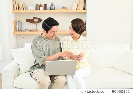 Middle-aged couple looking at a computer Middle-aged couple looking at a computer 90060391