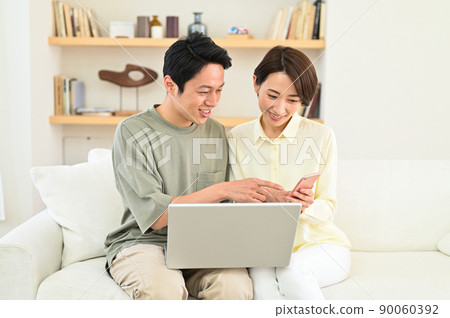 Middle-aged couple looking at a computer Middle-aged couple looking at a computer 90060392