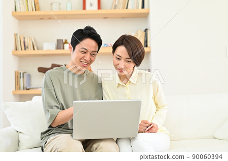 Middle-aged couple looking at a computer Middle-aged couple looking at a computer 90060394