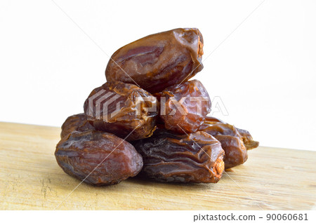 Organic fresh nutritious dried hurma dates medjool grains, on cutting board 90060681