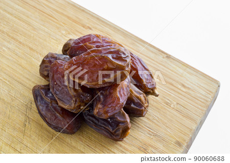 Organic fresh nutritious dried hurma dates medjool grains, on cutting board Organic fresh nutritious dried hurma dates medjool grains, on cutting board 90060688