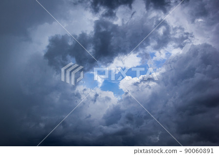 The dark sky had clouds gathered to the right and a strong storm before it rained. 90060891