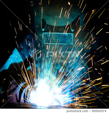 Welder uses torch to make sparks during manufacture of metal equipment Welder uses torch to make sparks during manufacture of metal equipment 90060914