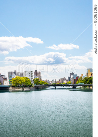 It is a building district along the river in Kyobashi-cho on the south exit side of Hiroshima Station. The front is Kamiyanagi Bridge on Jonan Dori. Please in a bright city background. 90061069