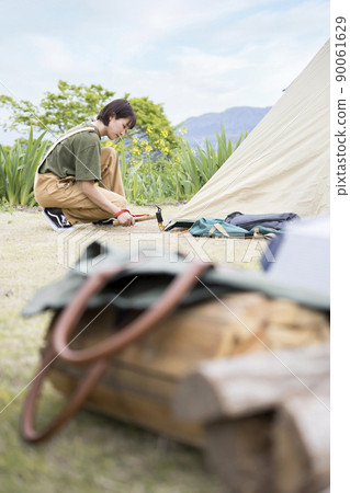 Young camp girls setting up tents 90061629