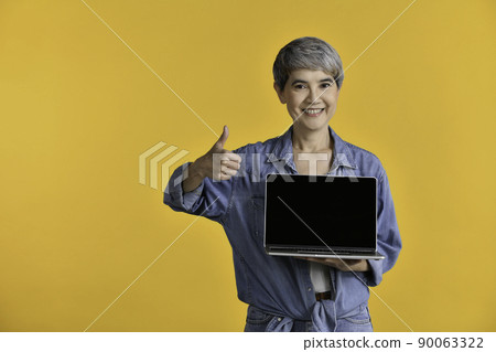 Portrait of middle aged Asian woman holding laptop computer 90063322