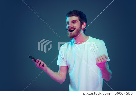 Portrait of excited, astonished man shouting isolated on dark blue studio background, Concept of human emotions, facial expression, sales, ad, fashion and beauty 90064596