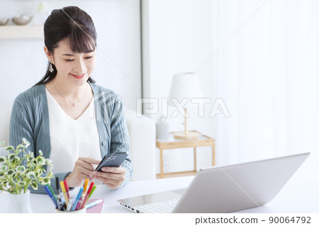 A woman operating a mobile phone A woman operating a mobile phone 90064792