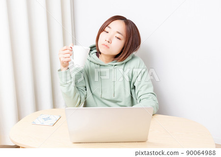A woman thinking while using a computer A woman thinking while using a computer 90064988