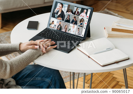 Online learning. Group video call. Remote education. Woman watching web lesson on laptop with coach students on screen in virtual home class. 90065017