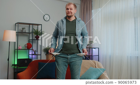 Upset poor man showing empty pockets inside out, having no money, bankruptcy, debts, poverty problem Upset poor man showing empty pockets inside out, having no money, bankruptcy, debts, poverty problem 90065973