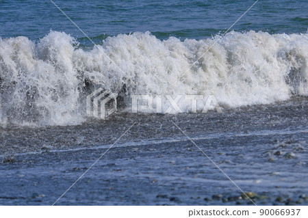 White waves crashing at the beach 90066937