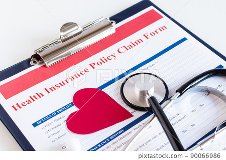 Blank health insurance policy claim form with stethoscope on clipboard. 90066986