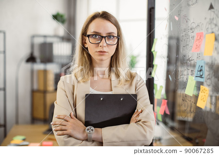 Lady marketer posing with crossed arms at business center Lady marketer posing with crossed arms at business center 90067285