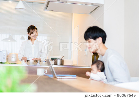Daddy using a computer with a baby Daddy using a computer with a baby 90067649