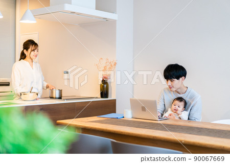 Daddy using a computer with a baby Daddy using a computer with a baby 90067669
