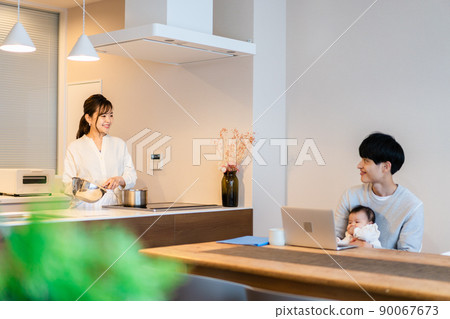 Daddy using a computer with a baby Daddy using a computer with a baby 90067673