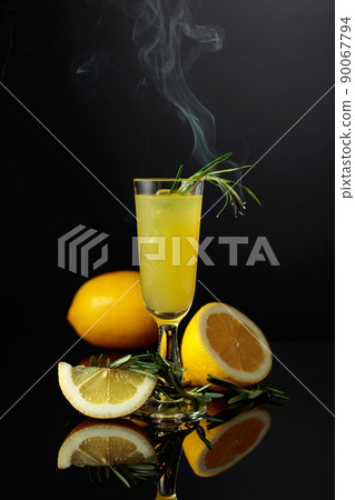 Traditional homemade lemon liqueur limoncello on the black background. Traditional homemade lemon liqueur limoncello on the black background. 90067794