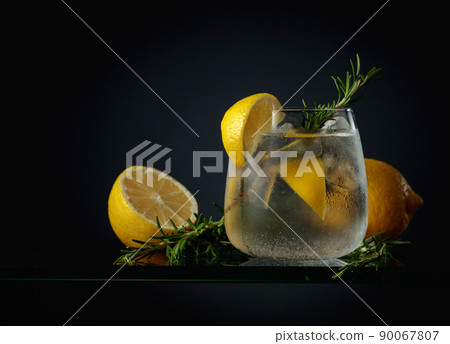 Cocktail gin tonic with ice, lemon, and rosemary. 90067807