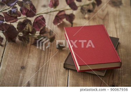 A book with a red cover placed on an old desk 90067936