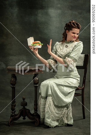 Emotional young beautiful girl, actress in image of medieval person posing isolated on dark background. Comparison of eras concept, flemish style. Art, beauty Emotional young beautiful girl, actress in image of medieval person posing isolated on dark background. Comparison of eras concept, flemish style. Art, beauty 90069202