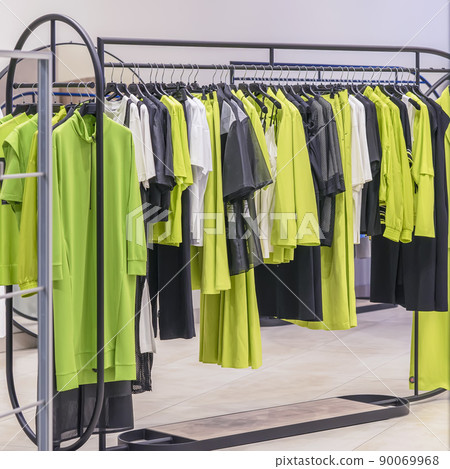 Colorful clothes on hangers, assortment in clothing store, season shopping. Fashion choice of clothes in bright colors Colorful clothes on hangers, assortment in clothing store, season shopping. Fashion choice of clothes in bright colors 90069968