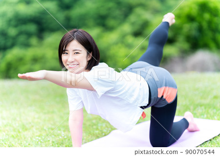 Young woman doing yoga in the fresh green 90070544